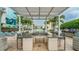 Outdoor kitchen featuring bar-stool seating, sink, and stainless steel fridge, surrounded by palm trees and blue skies at 777 N Ashley Dr # 1506, Tampa, FL 33602