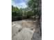 A backyard with a grassless and weedy yard and a partial fence at 7831 Fox Hollow Dr, Port Richey, FL 34668