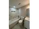 A full bathroom with a tub, sink, toilet, tile surround and a shower head at 7831 Fox Hollow Dr, Port Richey, FL 34668