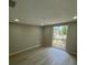 A bedroom with light colored laminate flooring, light gray paint, and natural light at 7831 Fox Hollow Dr, Port Richey, FL 34668