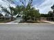 Street view of charming single-story home with a spacious front yard and attached garage at 7831 Fox Hollow Dr, Port Richey, FL 34668