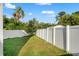 Well-maintained backyard featuring a lush lawn and a secure white fence at 7911 N Packwood Ave, Tampa, FL 33604