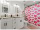 Bathroom with double vanities, granite countertop, and a colorful shower curtain at 7911 N Packwood Ave, Tampa, FL 33604