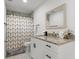 A clean bathroom featuring a white vanity, granite countertop, and a modern patterned shower curtain at 7911 N Packwood Ave, Tampa, FL 33604