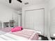 Bedroom with a ceiling fan and a mirrored closet with white bi-fold doors at 7911 N Packwood Ave, Tampa, FL 33604