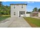 Two-story home with a modern exterior, front lawn, and concrete driveway at 7911 N Packwood Ave, Tampa, FL 33604