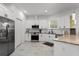 Well-lit kitchen with white cabinets, stainless steel appliances, and granite countertops at 7911 N Packwood Ave, Tampa, FL 33604