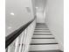 Staircase with white risers, dark wood treads, and white banister leading to upper level at 7911 N Packwood Ave, Tampa, FL 33604