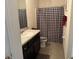 Well-lit bathroom with vanity, tile floors, and a shower with a stylish black and white curtain at 821 Lucent Sands Ct, Brandon, FL 33511