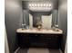Bathroom featuring double sinks, dark cabinets and stylish mirror at 821 Lucent Sands Ct, Brandon, FL 33511