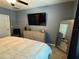 Bedroom with a large mounted TV, accent chair, dresser and decorative mirror at 821 Lucent Sands Ct, Brandon, FL 33511