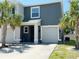 Two-story home with a two-car garage, palm trees, and a well-maintained front lawn at 821 Lucent Sands Ct, Brandon, FL 33511