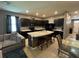Modern kitchen featuring sleek black cabinetry, granite countertops, and a functional center island at 821 Lucent Sands Ct, Brandon, FL 33511
