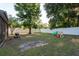 Spacious fenced backyard features a grill, playset, and mature trees at 8523 N Newport Ave, Tampa, FL 33604