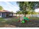 Beautiful backyard with covered porch, grill, playset, and perimeter fencing at 8523 N Newport Ave, Tampa, FL 33604