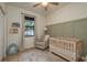 Comfortable Bedroom featuring a wood crib, beige chair, ceiling fan, and bright natural light at 8523 N Newport Ave, Tampa, FL 33604