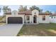 Charming home featuring a brown two-car garage and stucco facade with a beautiful lawn at 8523 N Newport Ave, Tampa, FL 33604