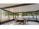 Enclosed patio features a dining table, chairs, and views of the backyard at 8523 N Newport Ave, Tampa, FL 33604