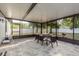 Enclosed patio features a dining table, chairs, and view of the yard at 8523 N Newport Ave, Tampa, FL 33604
