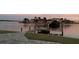 Lovely backyard with a dock and boat lift featuring lush lawn and waterfront views at sunset, offering a serene outdoor space at 861 180Th E Ave, Redington Shores, FL 33708