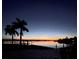 Breathtaking waterfront sunset view with palm trees and calm waters, creating a serene and picturesque scene at 861 180Th E Ave, Redington Shores, FL 33708