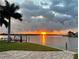 Beautiful waterfront view at sunset with lush lawns, docks and tranquil water reflections, enhancing the property's appeal at 861 180Th E Ave, Redington Shores, FL 33708