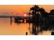 Stunning waterfront view at sunset, showcasing docks, palm trees, and tranquil water reflections, enhancing the property's appeal at 861 180Th E Ave, Redington Shores, FL 33708