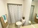 Neutral toned bathroom features a toilet and vanity with white patterned shower curtain at 8665 55Th N St, Pinellas Park, FL 33782