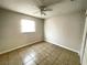 A simple bedroom with tile flooring, a ceiling fan, and a window for natural light at 8665 55Th N St, Pinellas Park, FL 33782