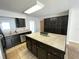A kitchen boasts an island with tile countertop, dark cabinetry, and stainless steel appliances at 8665 55Th N St, Pinellas Park, FL 33782