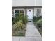 Close-up of townhouse exterior with brick accents and manicured garden at 8708 Cobbler Pl, Tampa, FL 33615