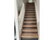 Staircase with two-tone wooden steps and white banister at 8708 Cobbler Pl, Tampa, FL 33615