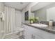 Bathroom featuring granite countertops, white cabinets, and shower-tub combo with neutral walls and floors at 8812 Parsons Hill Blvd, Wesley Chapel, FL 33545