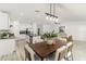 Open-concept kitchen and dining area featuring modern lighting, stainless steel appliances, and wood flooring at 8812 Parsons Hill Blvd, Wesley Chapel, FL 33545