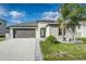Charming single-story home featuring a gray two-car garage, well-manicured lawn, and stylish landscaping at 8812 Parsons Hill Blvd, Wesley Chapel, FL 33545