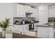 Bright kitchen featuring white cabinets, stainless steel appliances, and a tiled backsplash, seamlessly blending to dining area at 8812 Parsons Hill Blvd, Wesley Chapel, FL 33545