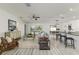 Spacious living room featuring an open floor plan, ceiling fan, large windows, and wood-look flooring at 8812 Parsons Hill Blvd, Wesley Chapel, FL 33545