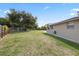 Wide shot of the backyard showcasing the lawn and side of the home at 8918 Carmen Ln, Port Richey, FL 34668