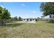 Wide shot of the backyard showcasing the lawn, swimming pool, and home at 8918 Carmen Ln, Port Richey, FL 34668