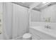 A clean and bright bathroom featuring a white vanity, mirror, and shower with a curtain at 8918 Carmen Ln, Port Richey, FL 34668