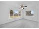 Bright bedroom with tile floors, a ceiling fan, and windows offering backyard views at 8918 Carmen Ln, Port Richey, FL 34668