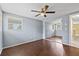 Bedroom featuring hardwood floors, a ceiling fan, a large mirrored closet, and a window with blinds at 8918 Carmen Ln, Port Richey, FL 34668