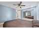 Cozy bedroom with a ceiling fan, light blue walls, tile flooring, and a mirrored closet at 8918 Carmen Ln, Port Richey, FL 34668
