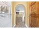 Inviting entryway with a carved wood door and herringbone-patterned floors, leading to an open-concept kitchen at 8918 Carmen Ln, Port Richey, FL 34668