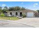 Charming stone-clad home featuring a well-manicured lawn, flower beds and an attached one car garage at 8918 Carmen Ln, Port Richey, FL 34668