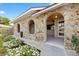 Detailed stone facade with arched entryways framing the tiled front porch entrance of this home at 8918 Carmen Ln, Port Richey, FL 34668