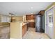 A spacious kitchen featuring tile floors, granite countertops, wooden cabinets, and stainless steel appliances at 8918 Carmen Ln, Port Richey, FL 34668