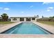 Back of home showcasing a rectangular pool surrounded by a brick patio and lush green lawn at 8918 Carmen Ln, Port Richey, FL 34668