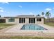 Home exterior featuring the pool and brick patio, with lush green lawn at 8918 Carmen Ln, Port Richey, FL 34668