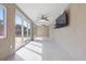 Bright sunroom featuring tile floors, a ceiling fan, and glass sliding doors to the backyard at 8918 Carmen Ln, Port Richey, FL 34668